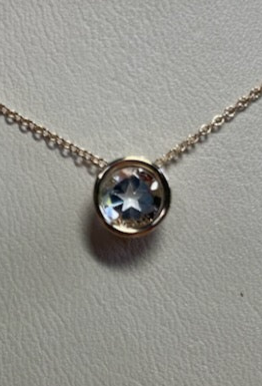 0.95 ct clear star brilliant cut Texas topaz is set in a 14kt gold bezel slide pendent on a gold chain.