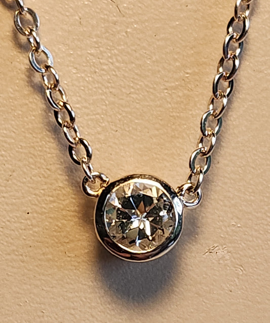 0.45ct clear star brilliant cut Texas topaz is set in a small sterling silver filigree bezel pendant and silver chain