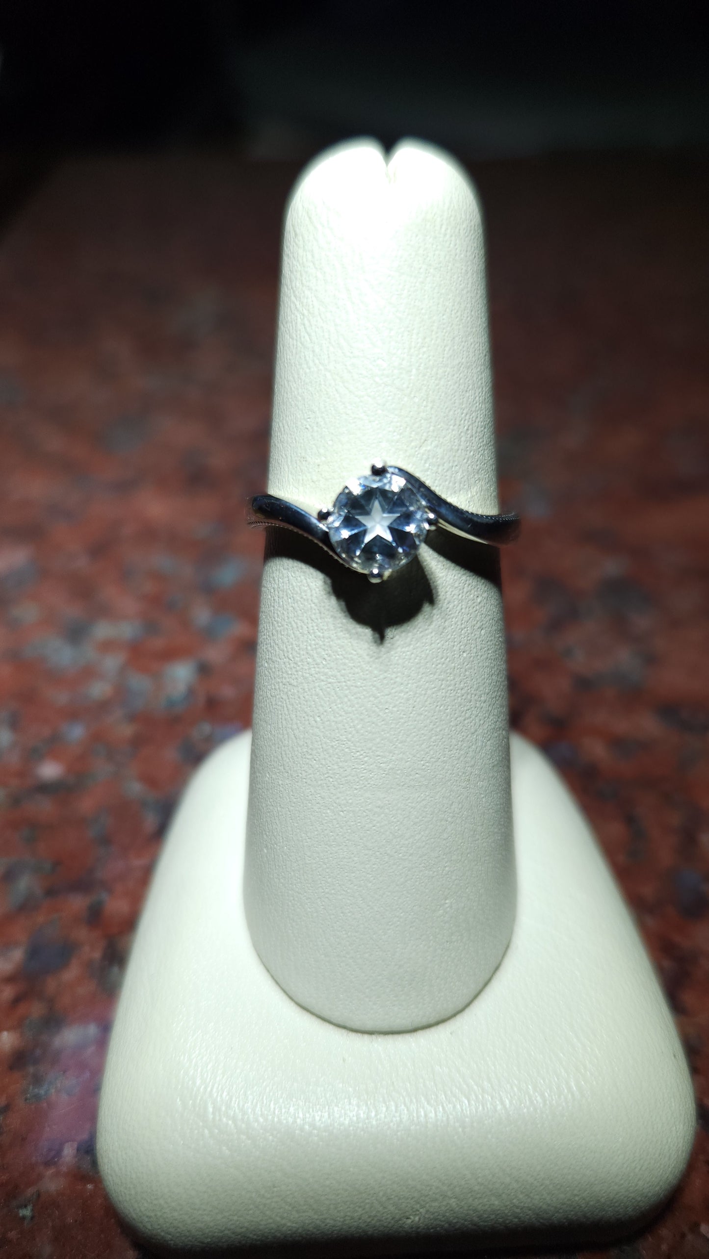 0.95ct Mason County clear star brilliant cut topaz mounted in a bypass style ring in contiuum silver.