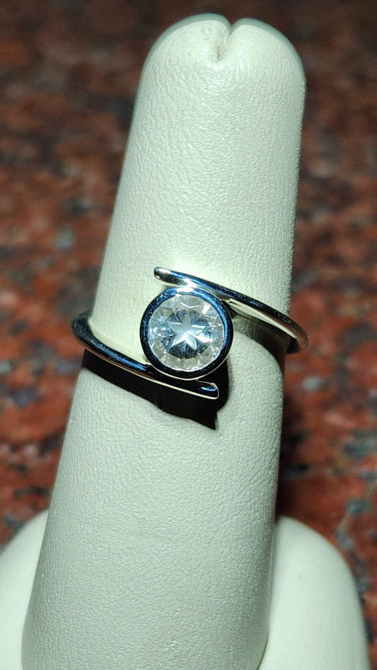 0.95ct Mason County clear star brilliant cut topaz bezel set in a bypass style ring in contiuum silver.