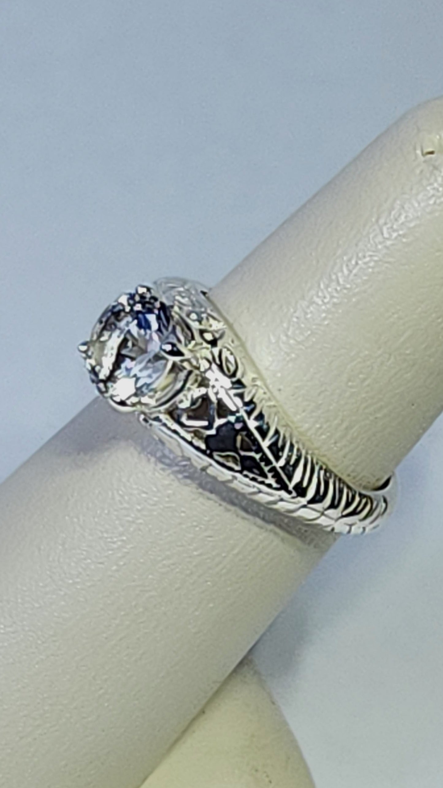 0.95ct clear star brilliant cut Texas topaz is set in a sterling silver filigree ring with hearts.