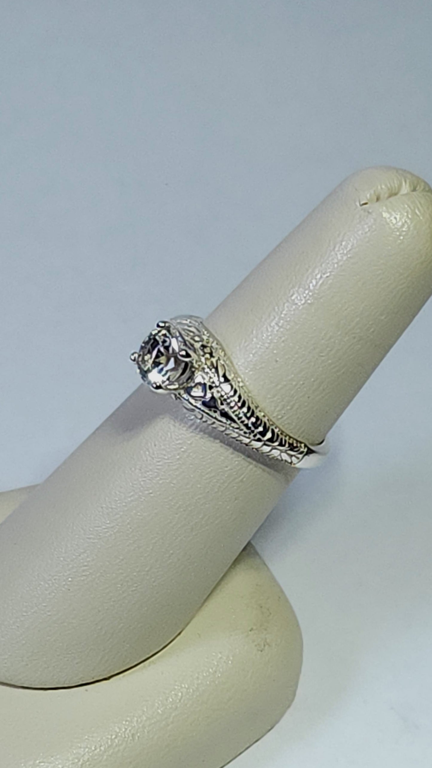 0.54ct clear star brilliant cut Texas topaz is set in a sterling silver filigree ring with hearts.