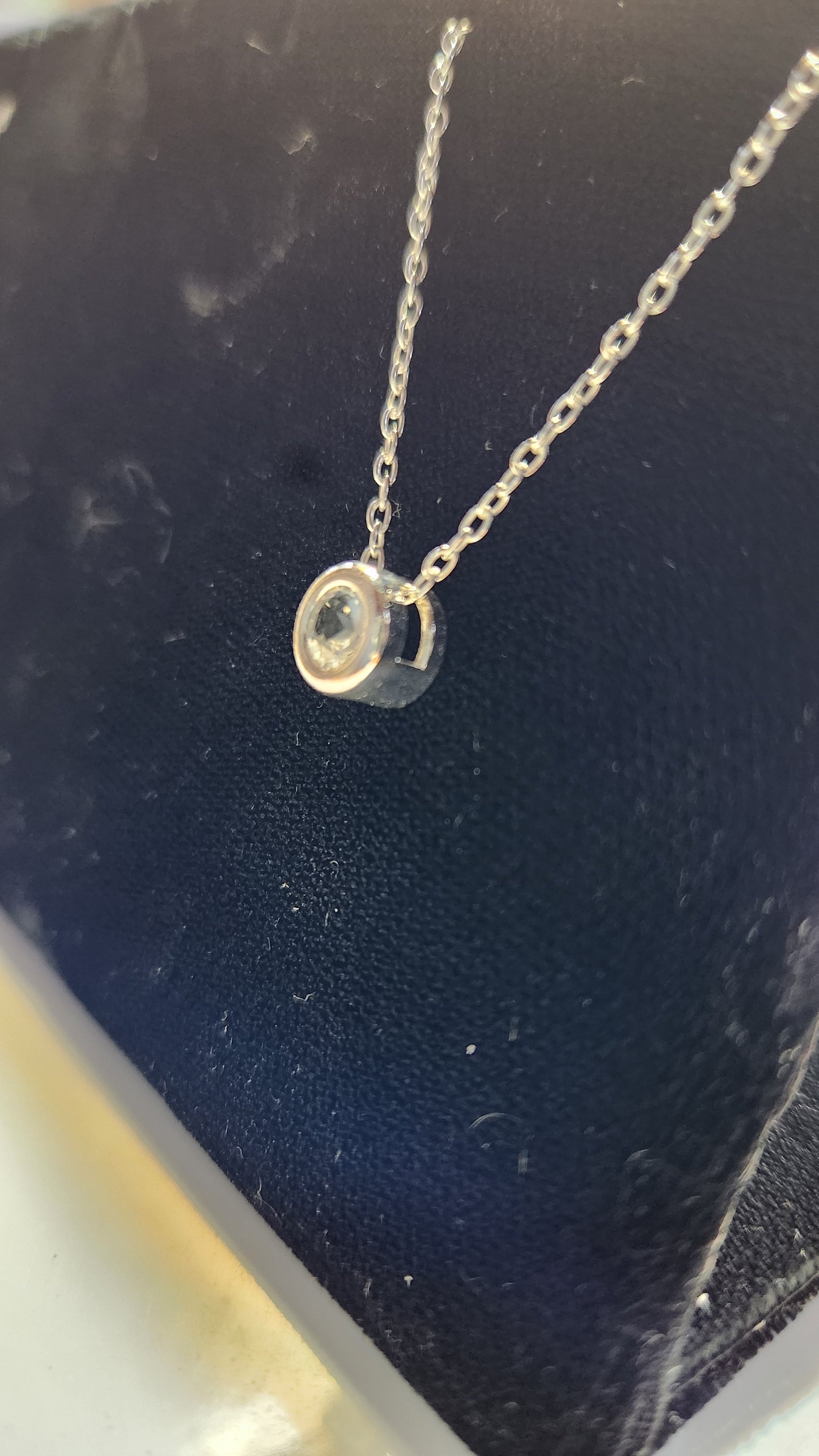 0.50ct clear star brilliant cut Texas topaz is back-set in a sterling silver slide pendant and chain.