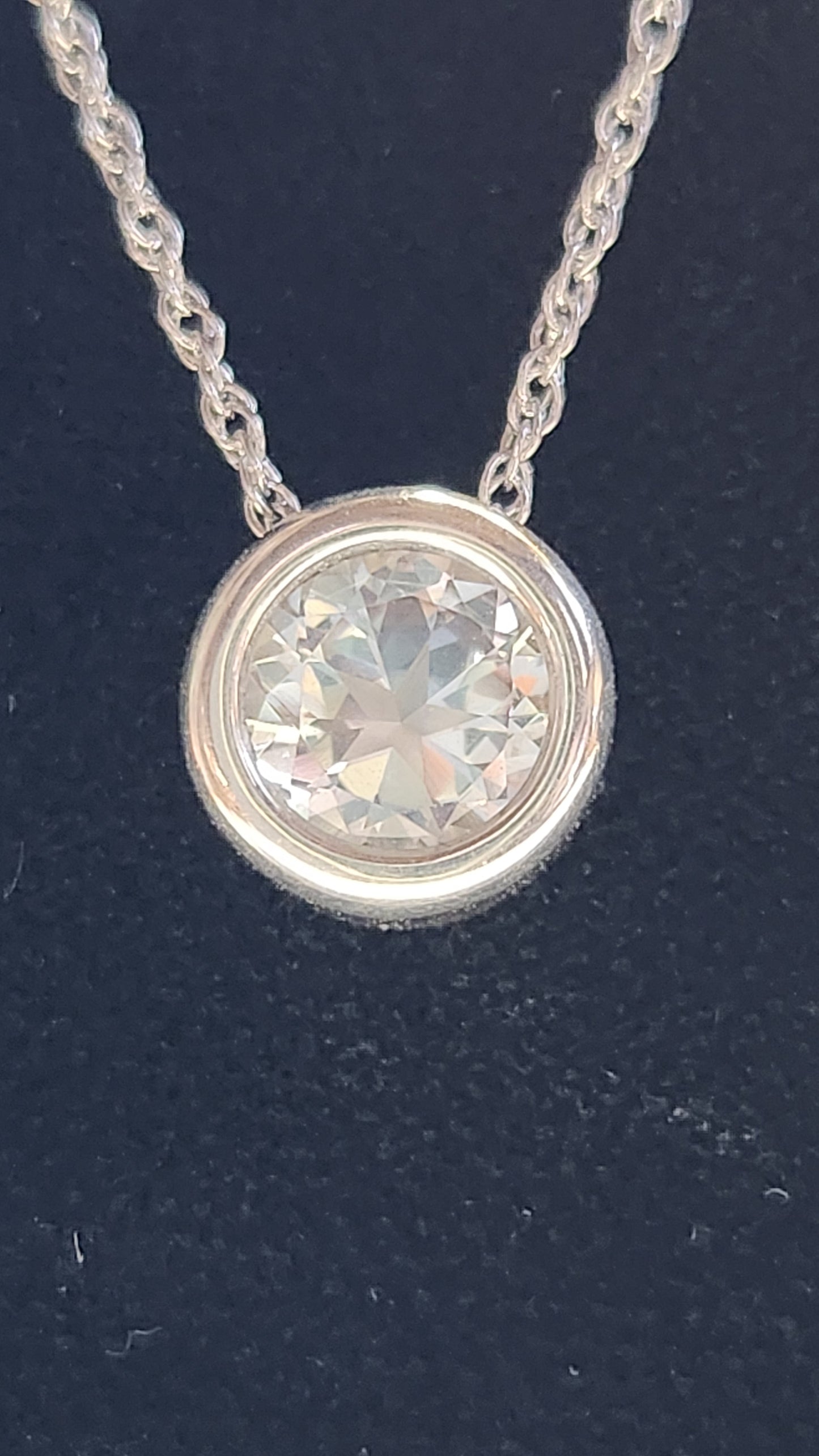 1.45ct clear star brilliant cut Texas topaz is back-set in a sterling silver slide pendant and chain.