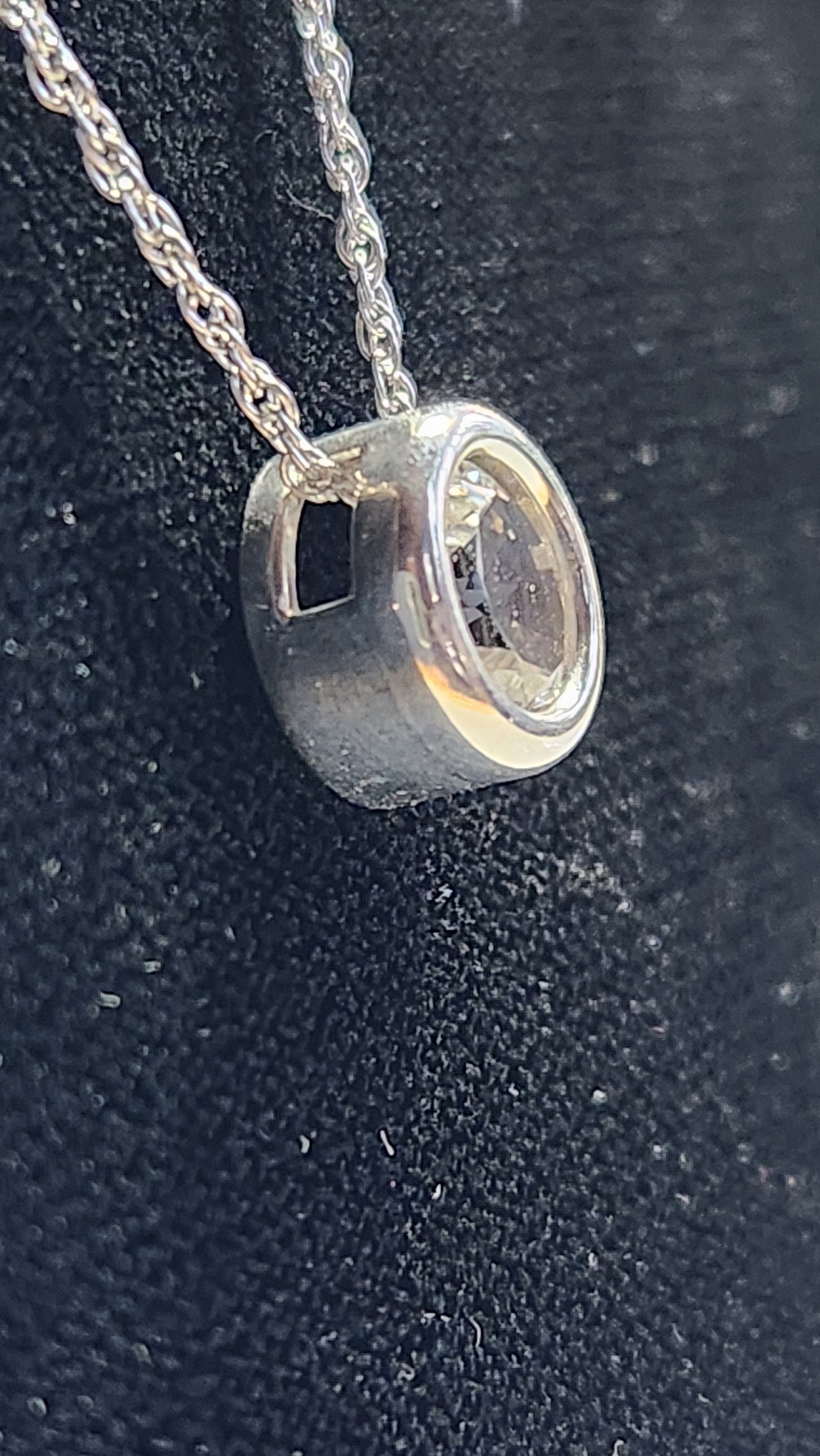 1.45ct clear star brilliant cut Texas topaz is back-set in a sterling silver slide pendant and chain.