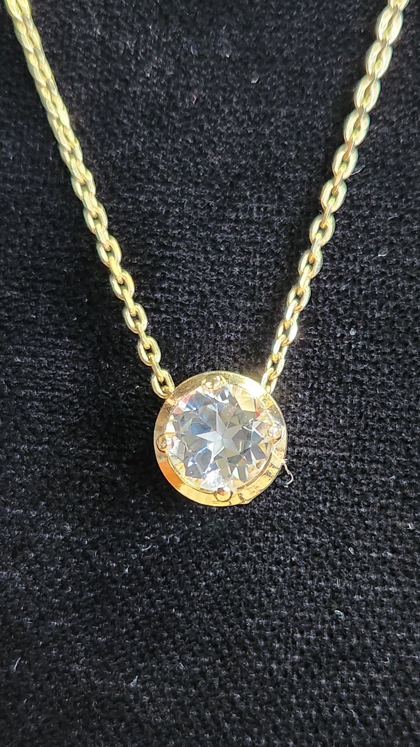 1.45 ct clear star brilliant cut Texas topaz is set in a 14kt gold bezel slide pendent on a gold chain.