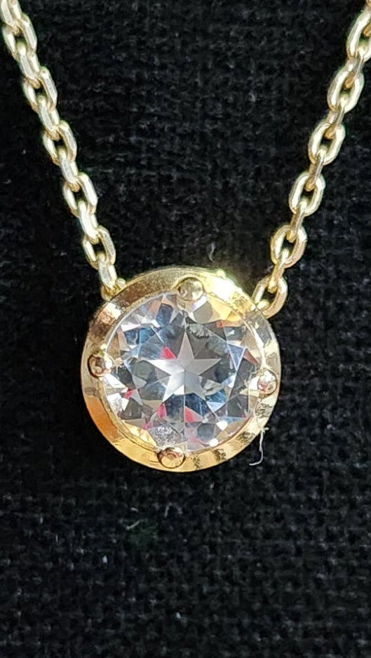 1.45 ct clear star brilliant cut Texas topaz is set in a 14kt gold bezel slide pendent on a gold chain.