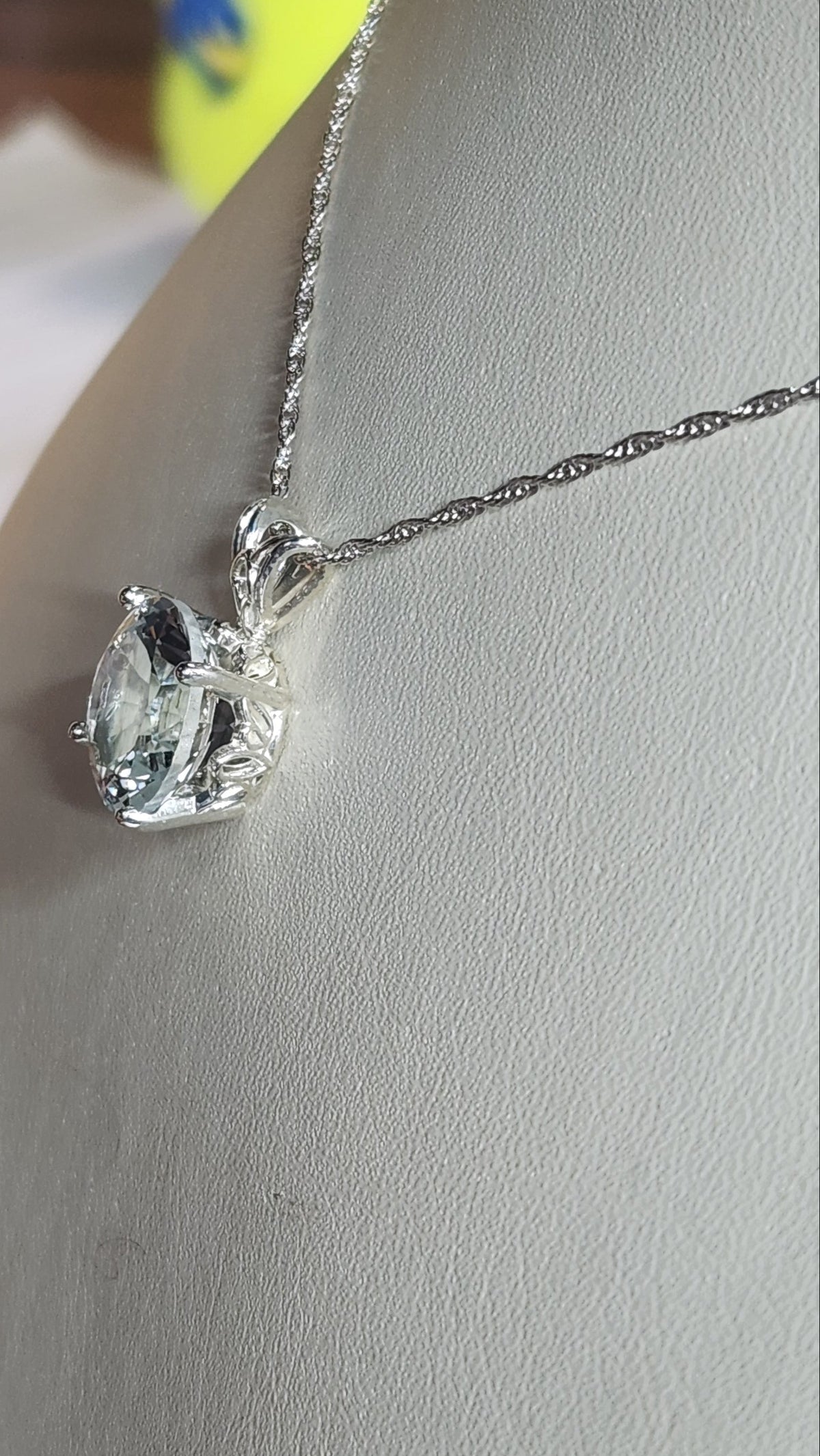 7.67ct clear star brilliant cut Texas topaz is set in a sterling silver scroll pendant and chain.