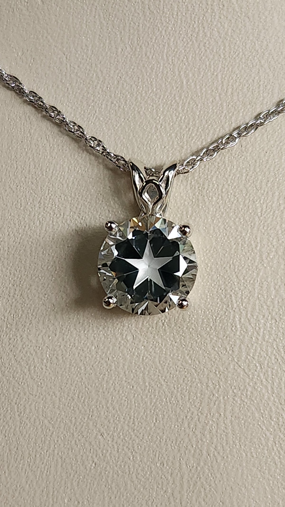 3.20ct natural blue star brilliant cut Texas topaz is set in a sterling silver scroll pendant and chain.