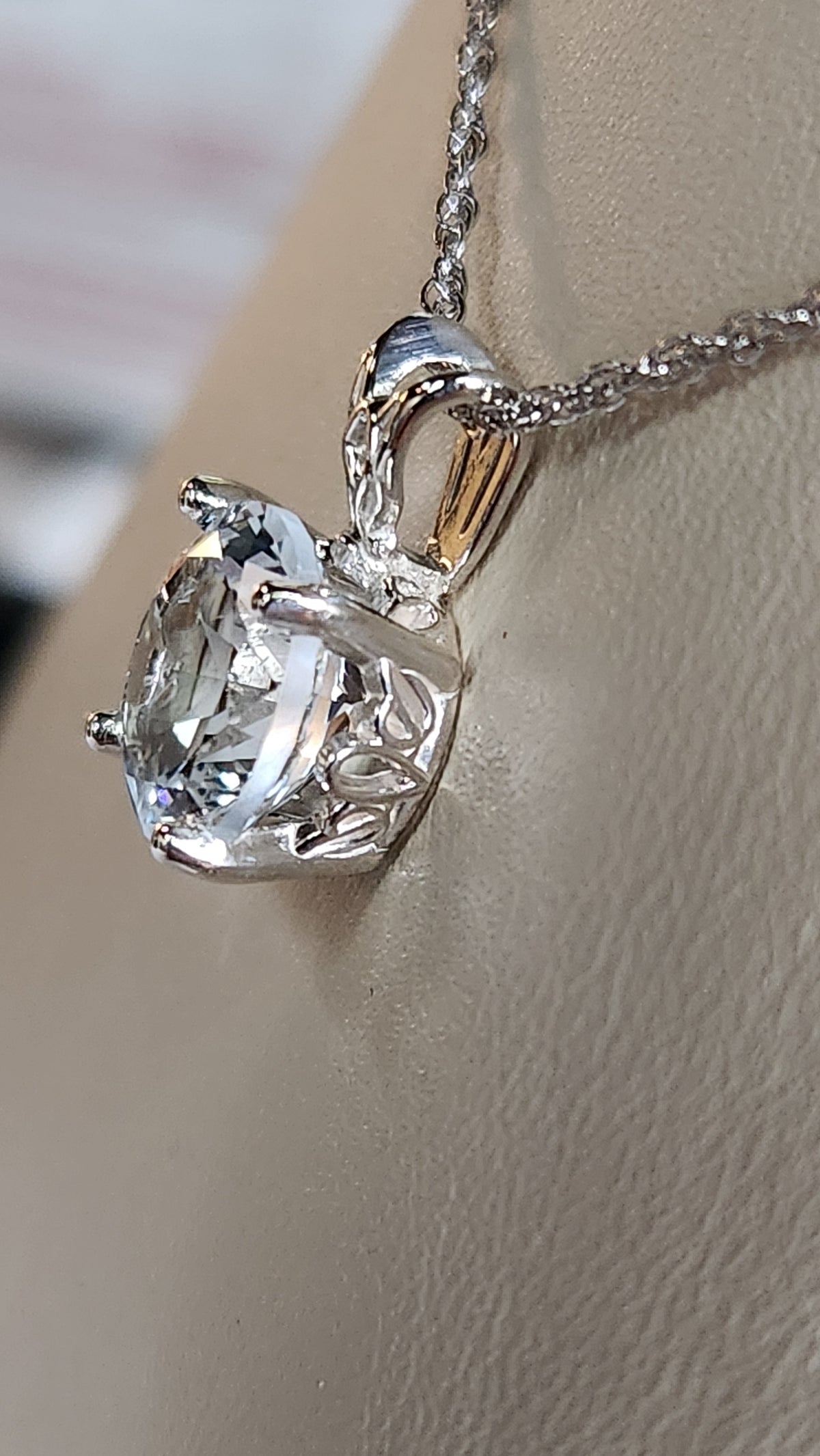 3.20ct natural blue star brilliant cut Texas topaz is set in a sterling silver scroll pendant and chain.