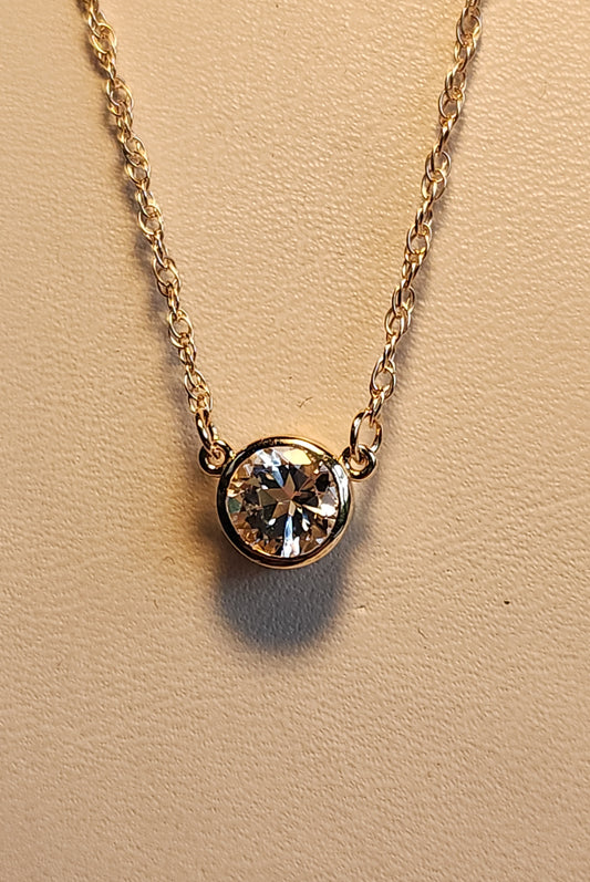 0.95 ct clear star brilliant cut Texas topaz is set in a small 14kt gold bezel on a gold chain.